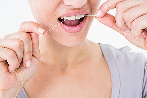 Woman using dental floss on white background