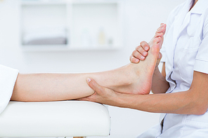 Physiotherapist doing foot massage in medical office