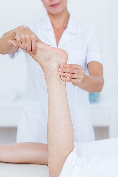 Physiotherapist doing foot massage in medical office