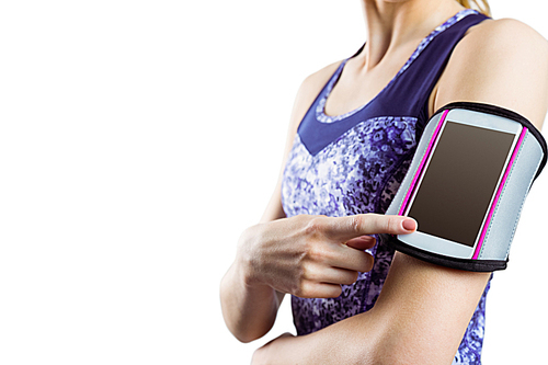 Fit woman using smartphone in armband on white background