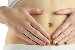 Slim woman touching her belly on white background