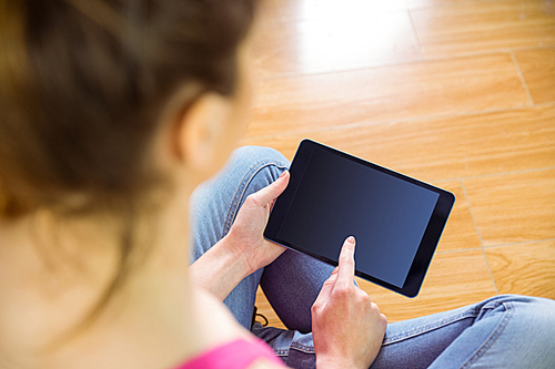 Casual woman using her tablet pc at home in the living room