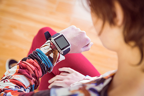 Slim woman looking at her smart watch at home