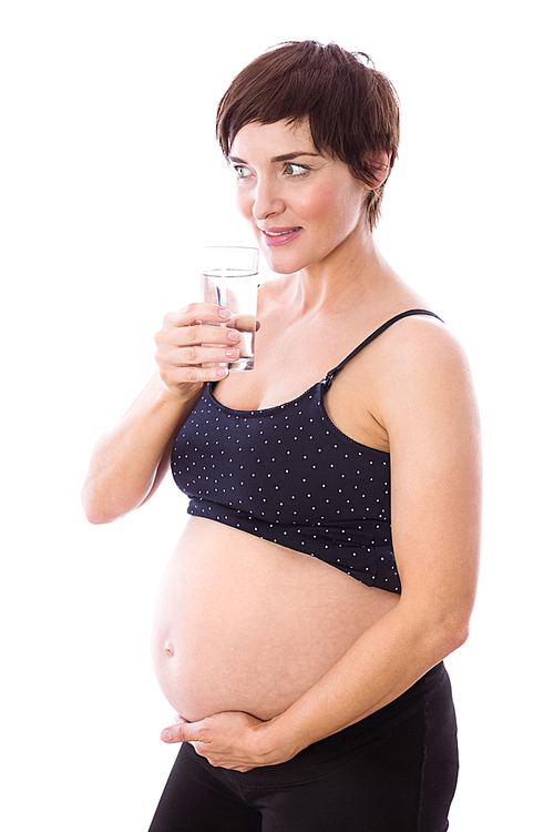 Pregnant woman drinking glass of water on white background