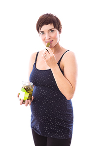 Pregnant woman eating jar of pickles on white background