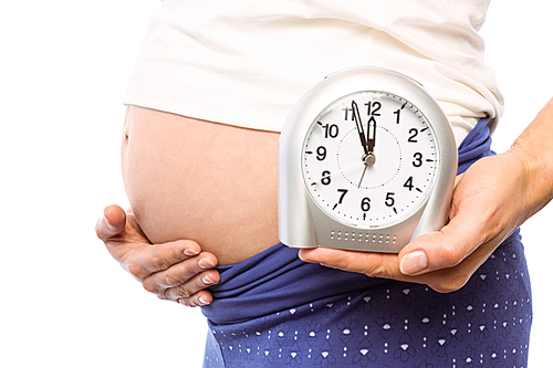 Pregnant woman showing clock and bump on white background