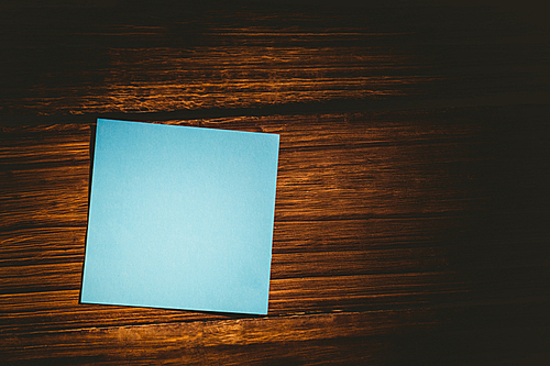 Blue post it on wooden background