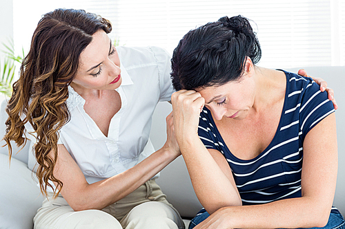 Therapist comforting her patient on white background