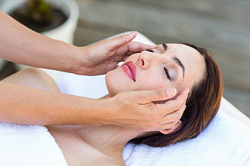 Brunette receiving head massage at the spa