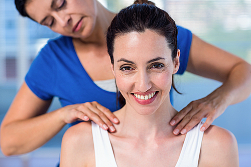 Therapist doing back massage to her patient in medical office