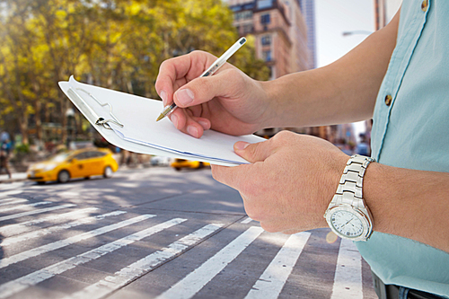 Composite image of delivery man writing on clipboard