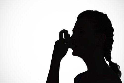 Composite image of woman using inhaler for asthma