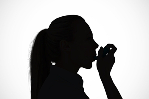 Composite image of pretty blonde using an asthma inhaler