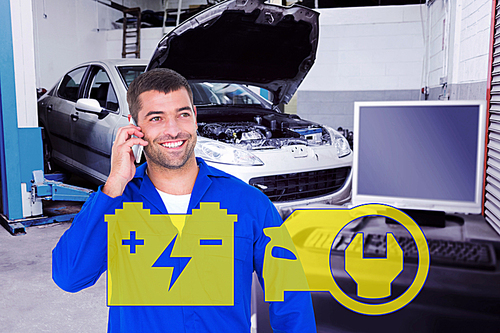 Composite image of smiling male mechanic using mobile phone