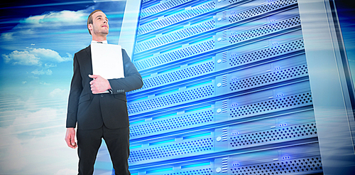 Composite image of businessman looking up holding laptop