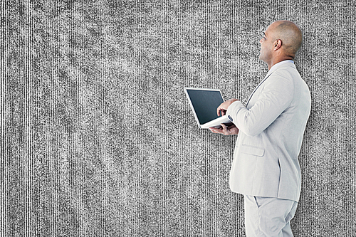 Composite image of businessman using laptop