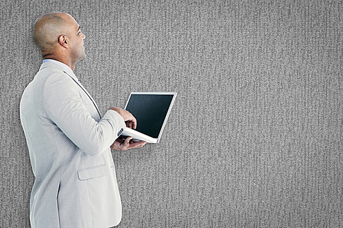 Composite image of businessman using laptop