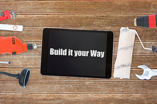 Build it your way against tools and tablet on wooden background