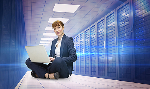 Composite image of businesswoman using laptop