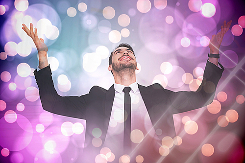 Composite image of businessman cheering with hands raised