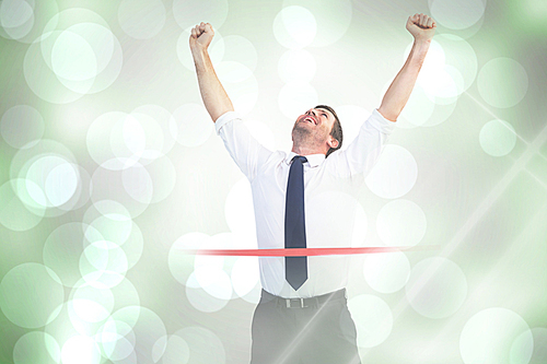 Composite image of businessman celebrating success with arms up