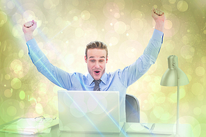 Composite image of cheering businessman at laptop