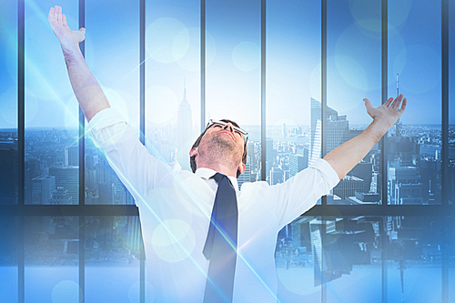 Composite image of handsome businessman cheering with arms up