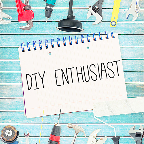 Diy enthusiast against tools and notepad on wooden background