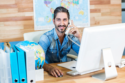 Smiling travel agent having phone call