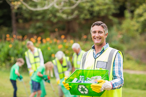 Happy family collecting rubbish on a sunny day