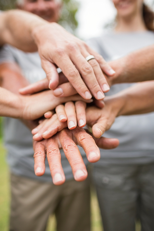 Happy volunteer family putting their hands together on a sunny day