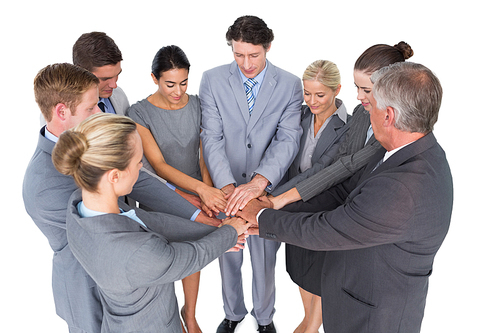 Smiling business team standing in circle hands together on white background