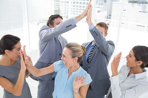 Excited business team cheering in the office