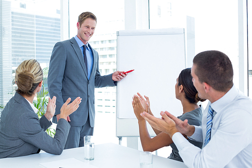 Manager presenting whiteboard to his colleagues in the office