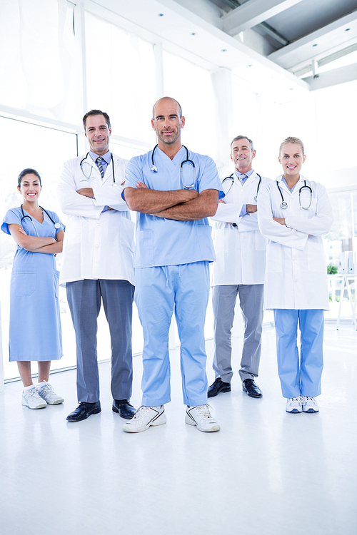 Team of smiling doctors  with arms crossed in medical office