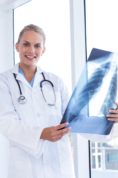 Smiling female doctor looking at Xray in medical office