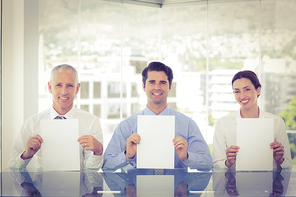 Smiling business team showing paper in the office