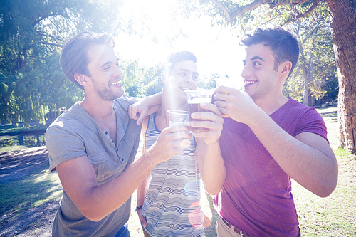 Happy friends in the park having beers on a sunny day