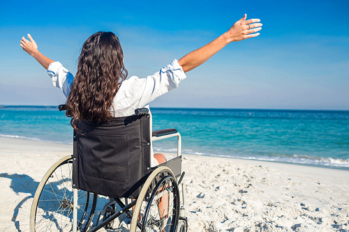 Disabled woman with arms outstretched at the beach on a sunny day