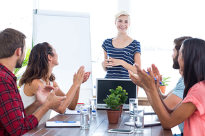 Young business team clapping hands in a meeting