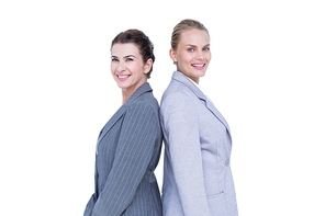 Attractive businesswomen standing back-to-back against white wall