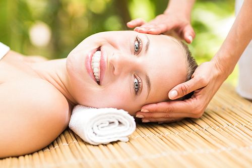 Close up of an attractive young woman receiving facial massage at spa center