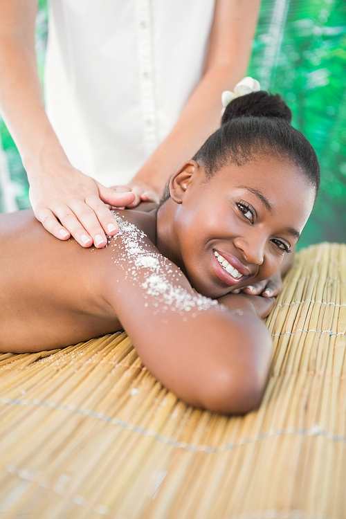 Portrait of a pretty woman enjoying a salt scrub massage at the health spa