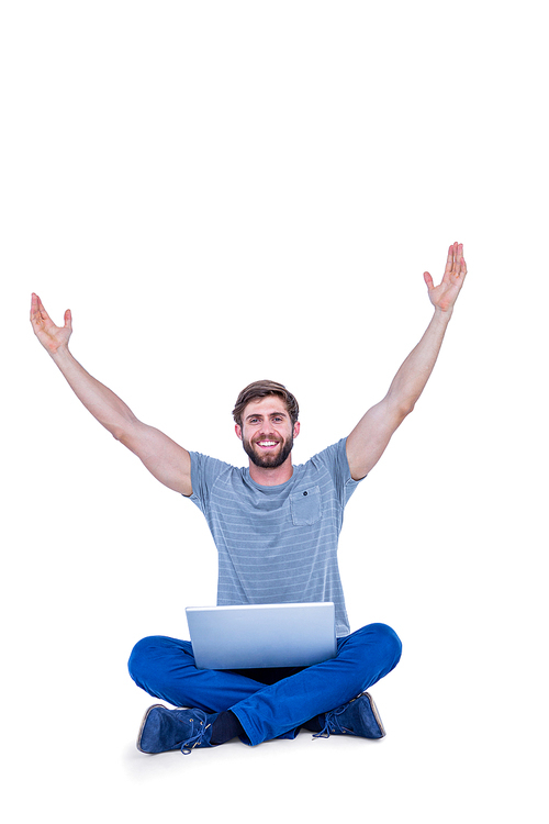 Happy handsome man cheering behind his computer on white background