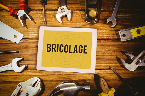 The word bricolage and tablet pc against blueprint