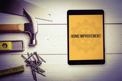 The word home improvement and tablet pc against blueprint