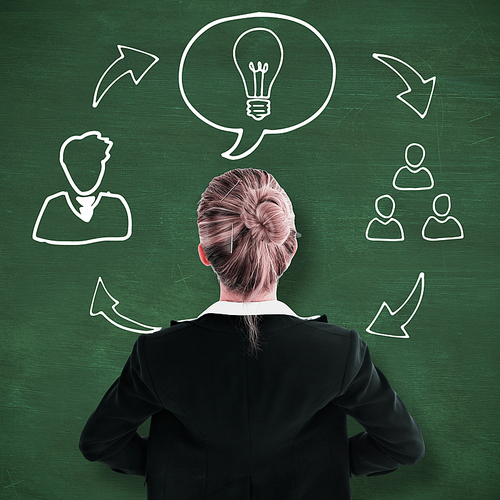 Businesswoman standing with hands on hips against green chalkboard