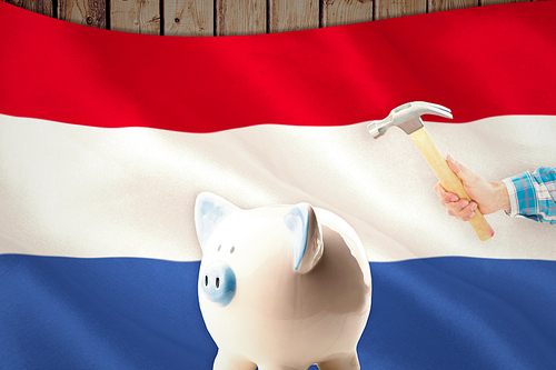 hand holding hammer against digitally generated netherlands national flag