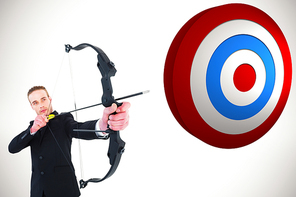 Concentrated businessman shooting a bow and arrow against white background with vignette