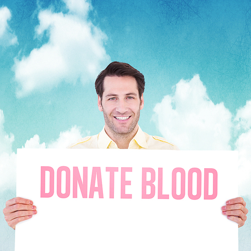 Attractive man smiling and holding poster against blue sky